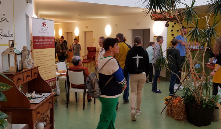 Zu sehen sind Besucherinnen und Besucher, die sich im Hospizgebäude umsehen