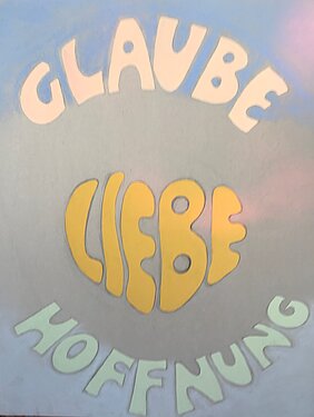 Zu sehen ist ein Plakat mit dem Titel "Glaube - Liebe - Hoffnung"