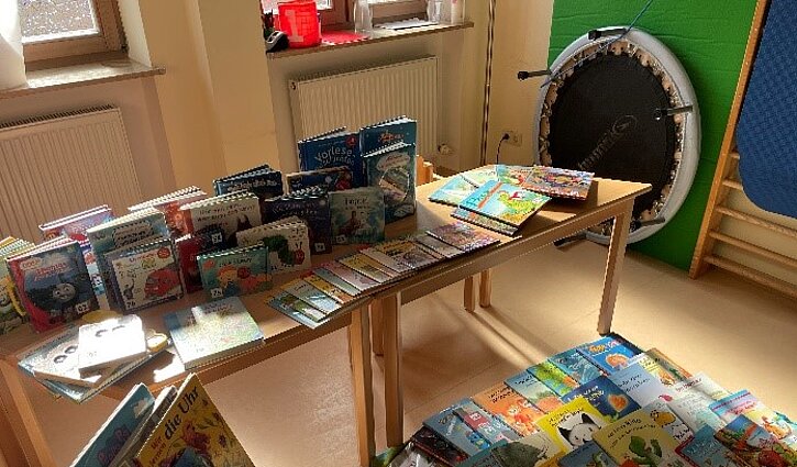 Auf Tischen stehen und liegen viele Bücher, die nun den Anfang für eine kleine Bibliothek bilden