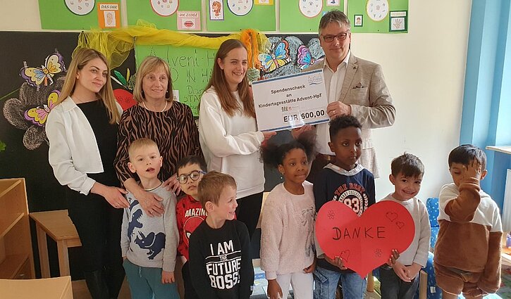 Das Bild zeigt eine Gruppe von Kindern mit Marina Galic, Erzieherin der Advent-HPT, Frau Radlmair von den Stadtwerken Neuburg, Andrea Forster, die Leiterin der Einrichtung und Herr Frank von den Stadtwerken Neuburg