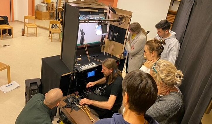 Zu sehen sind Mitarbeitende bei der Präsentation von Schattenspielen