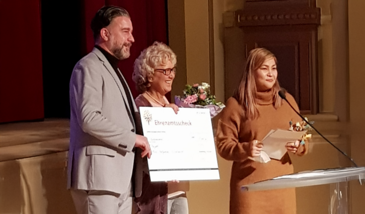 Das Bild zeigt die Leiterin Doris Lang und Sara Rasuli, die eine Auszeichnung entgegen nehmen
