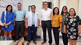 Zu sehen sind Volkmar Proschwitz und Georg Remmert mit Vertreterinnen philippinischer Collages