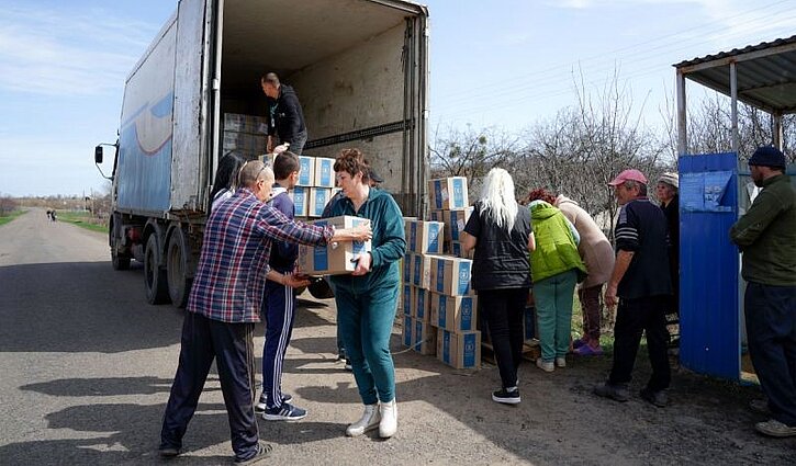 Hilfspaktete werden in der Ukraine von einem ADRA-LKW entladen.