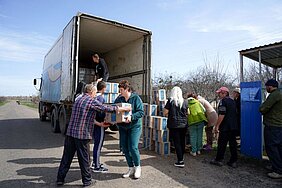 Hilfspaktete werden in der Ukraine von einem ADRA-LKW entladen.