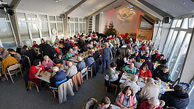 Blick in den gut mit den Gästen der Weihnachtssuppenküche gefüllten Gemeindesaal der Adventgemeinde Ludwigsburg