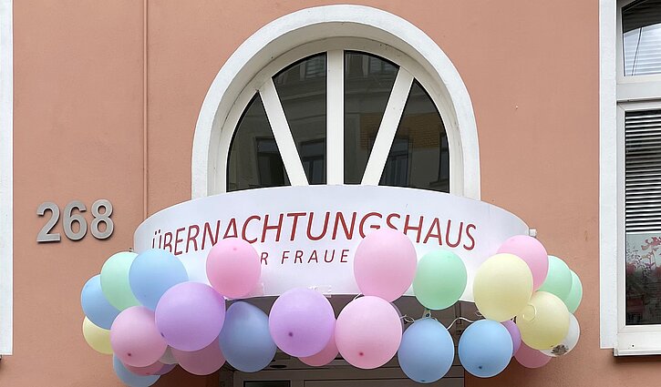 Das Bild zeigt einen Teil des mit Luftballons geschmückten Eingang des Übernachtungshauses